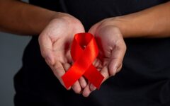 Woman hand holding red ribbon HIV awareness concept World AIDS D